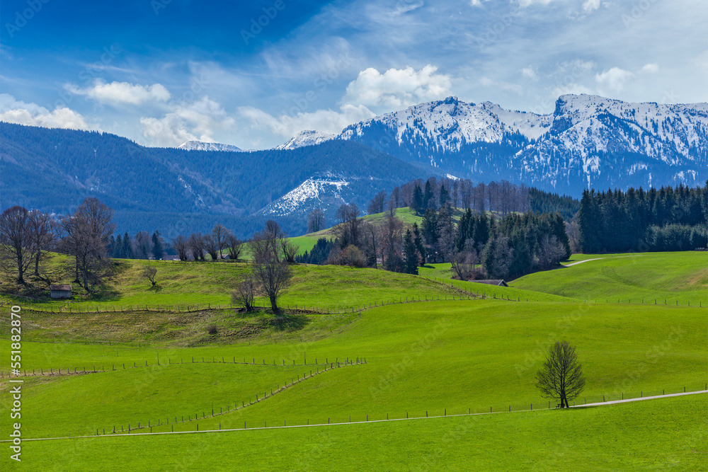 German idyllic pastoral countryside in spring with Alps in background. Bavaria, Germany