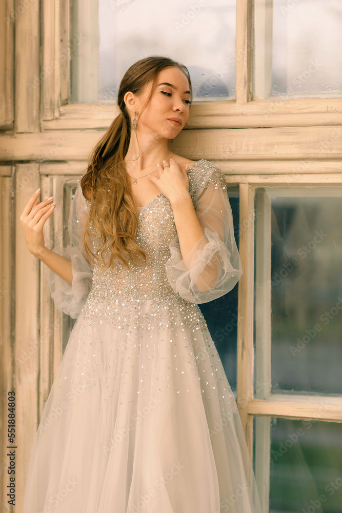 a girl in a dress by the window