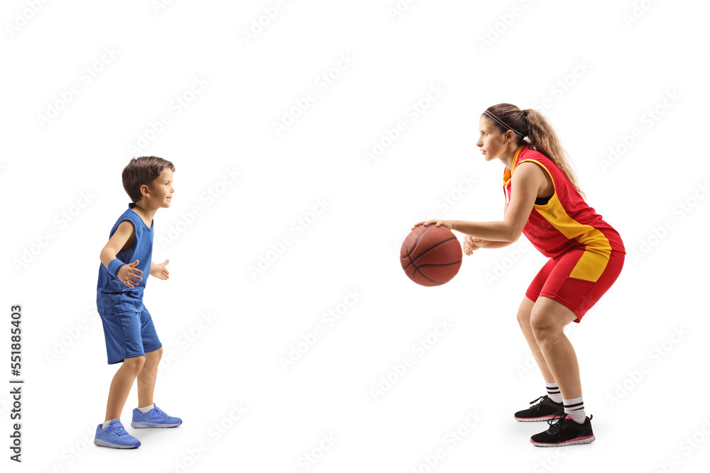 Full length profile shot of a female adult playing basketball with a little boy