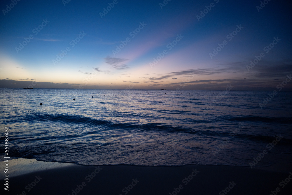 Obraz premium purple and pink sunset over a Caribbean beach in nigril, Jamaica