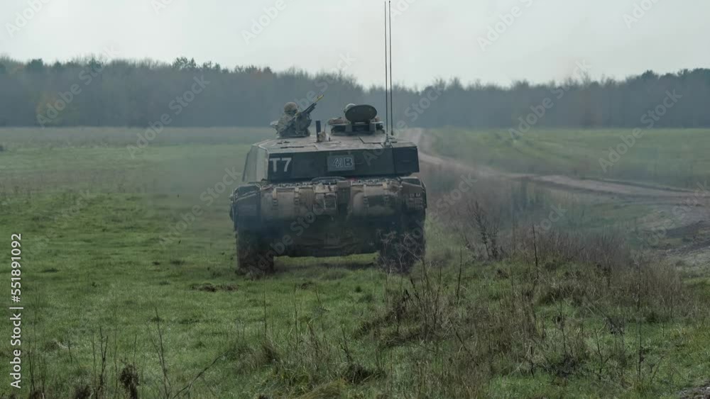 close-up rear view of a British army FV4034 Challenger 2 ii main battle tank driving away across a grass meadow at speed on a military battle exercise, Wiltshire UK close-up rear view of a British army FV4034 Challenger 2 ii main battle tank driving away across a grass meadow at speed on a military battle exercise, Wiltshire UK