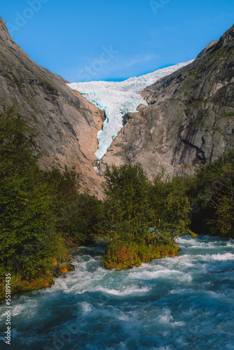 View of Briksdalsbreen glacier with small glacial river in front, Norway