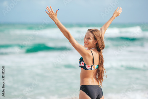 Adorable slim girl in a swimsuit with a perfect figure on the beach