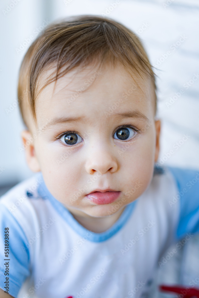 Little toddler boy close up in his house. Handsome toddler portrait. Joyful childhood and parenthood.