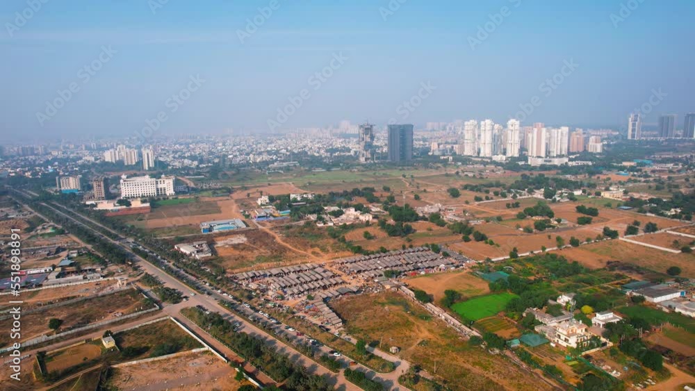 aerial drone flying towards banjara market in gurgaon delhi showing disorganized temporary tents houses in slums showing this famous handicraft and furniture market surrounded by empty land with aerial drone flying towards banjara market in gurgaon delhi showing disorganized temporary tents houses in slums showing this famous handicraft and furniture market surrounded by empty land with
