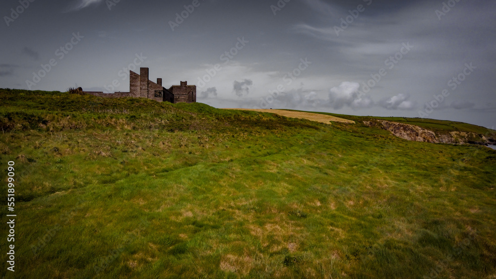 An old unfinished building on a green hill. Beautiful sky with clouds. Drone point of view. An old unfinished building on a green hill. Beautiful sky with clouds. Drone point of view.