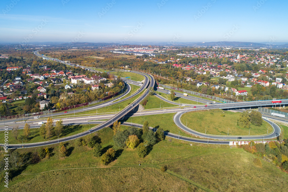 Highway multilevel crossing. Interchange junction on A4 international highway with Zakopianka multilane road and railway. A part of freeway around Krakow, Poland. Aerial view.