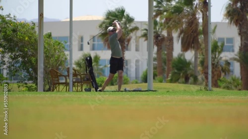 Driving Range Golf. Man practicing with golf club. Slow motion