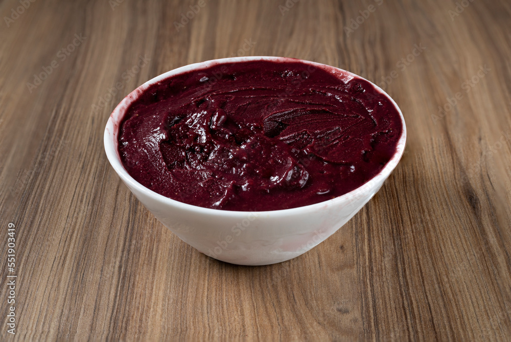 White Bowl of Brazilian Frozen Açai Berry. on a wooden desk White Bowl of Brazilian Frozen Açai Berry. on a wooden desk