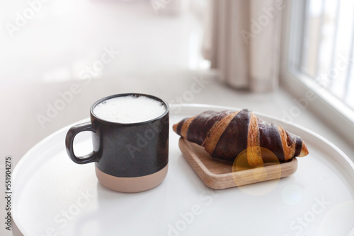 Coffee and croissant on white table. French breakfast. Copy space for your text