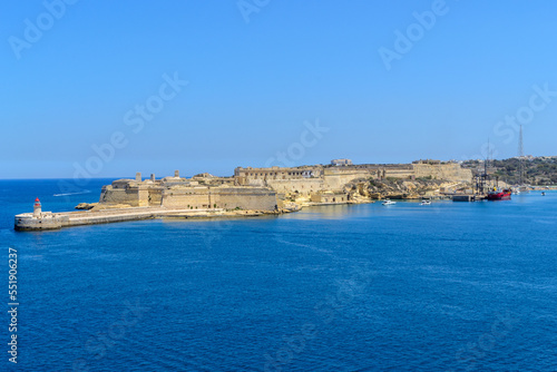 Fototapeta Naklejka Na Ścianę i Meble -  The entrance to the Grand Harbour in Malta protected by Fort Ricasoli. In front of the fort is the Ricasoli Breakwater and its lighthouse.
