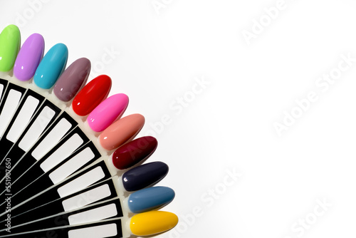 Nail polish samples of different bright colors on a white background. Colorful manicure samples with nail polish. Top view of the gel polish palette for nail art. place for text
