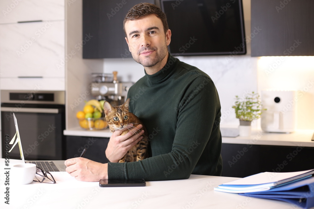 Attractive man working from home with his cat Attractive man working from home with his cat