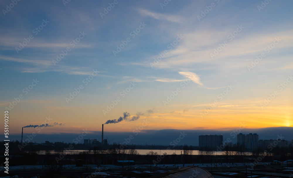 coal power plant high pipes with black smoke moving up polluting atmosphere at sunset in Kyiv city of Ukraine.