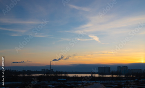 coal power plant high pipes with black smoke moving up polluting atmosphere at sunset in Kyiv city of Ukraine. © Mykola