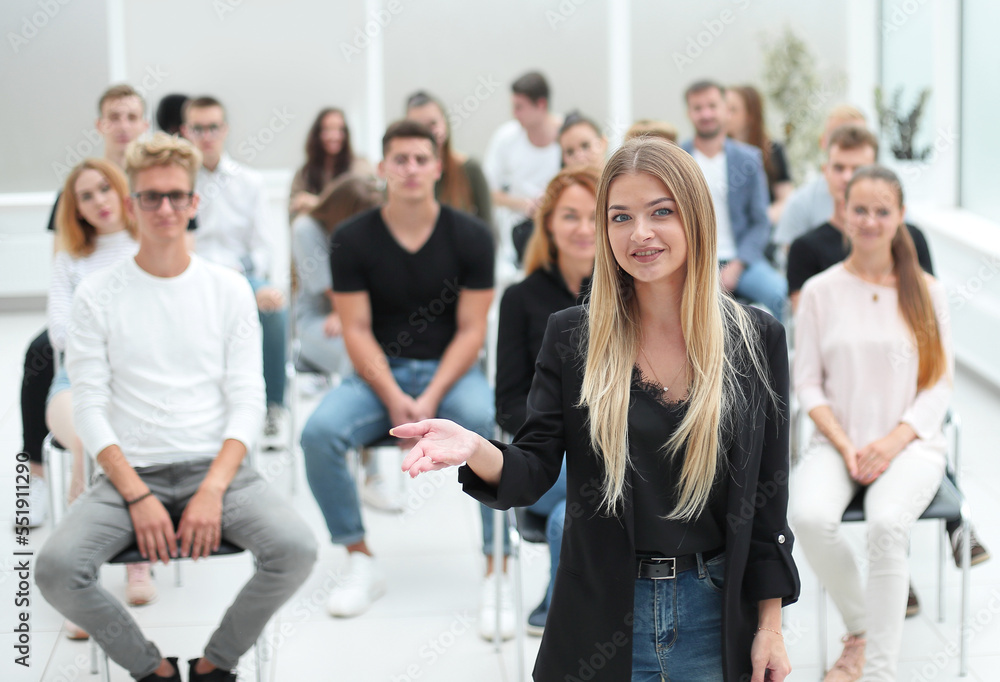 young woman standing in front of an audience in a conference roo