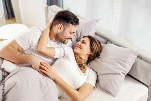 Canvas Print A romantic couple is cuddling in bed in the morning.