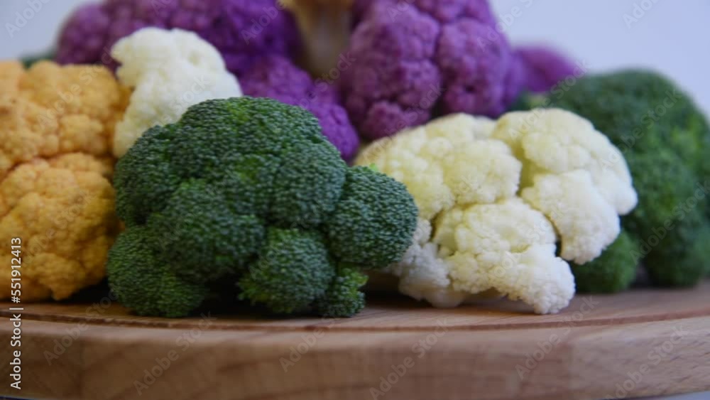 Side view of spinning multi colored cauliflower and broccoli cabbages against white background. Real time video. Selective focus. Healthy eating theme. Side view of spinning multi colored cauliflower and broccoli cabbages against white background. Real time video. Selective focus. Healthy eating theme.