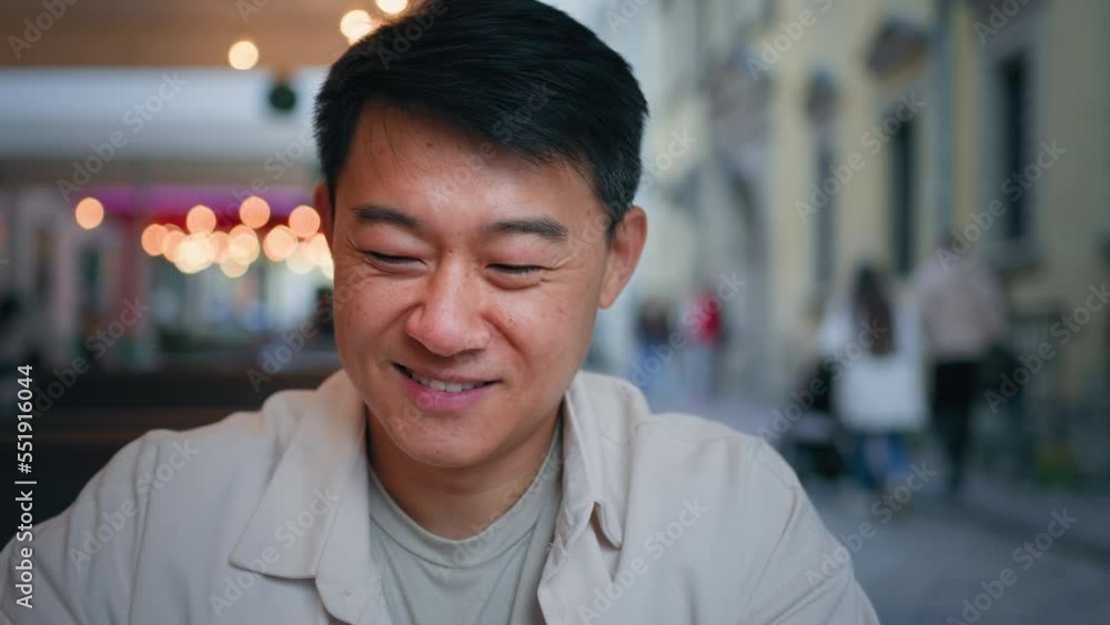 Happy carefree man asian tourist sitting in cafe drinking coffee male traveler pleased client resting enjoying fragrant drink relaxing in restaurant drinks hot cappuccino spend free time taking break Happy carefree man asian tourist sitting in cafe drinking coffee male traveler pleased client resting enjoying fragrant drink relaxing in restaurant drinks hot cappuccino spend free time taking break