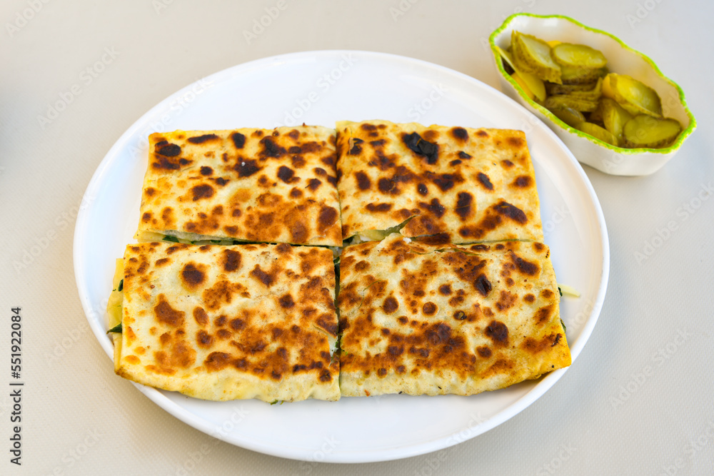 Freshly baked appetizing Turkish tortillas - Gozleme with spinach, cheese  on a wooden board. Space for text. Shallow depth of  field. Handmade Turkish traditional pastries.