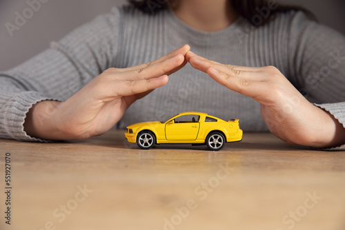 Woman hand protecting a small car