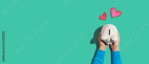 Person holding a piggy bank with hearts