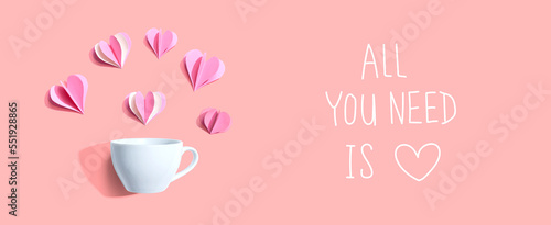 All you need is love message with a coffee cup and paper hearts - flat lay