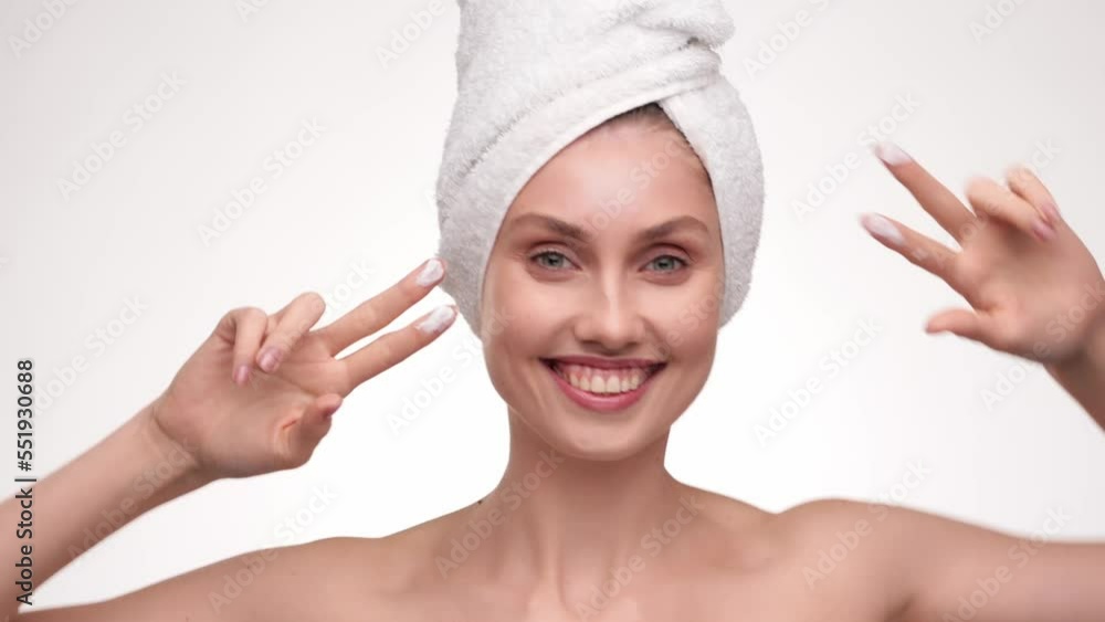 Happy smiling young woman putting cream on her chick and playing, laughing. Perfect skin and beautiful smile with cream beauty model with perfect skin isolated on white background. Slow motion.