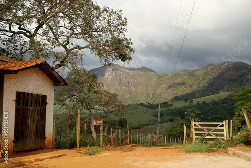 
Rural scene of the field with a dirt road and trees in the city of Serro, Cabeça de Boi village in Minas Gerais. In the background, nature with green vegetation and mountains. photo