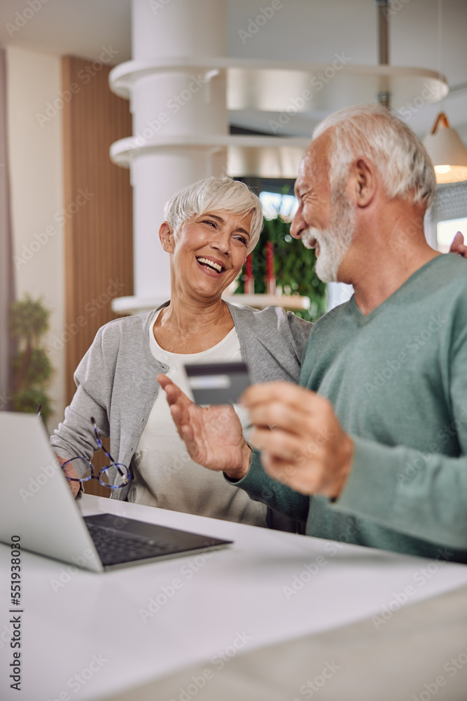 happy senior couple shopping online using laptop and credit card happy senior couple shopping online using laptop and credit card