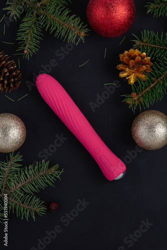 New Year or Christmas festive background for Sex shop. Top view on  sex toys golden silver and gold deco baubles and Christmas tree. Image for the festive season and sales. Adult store. Space for text