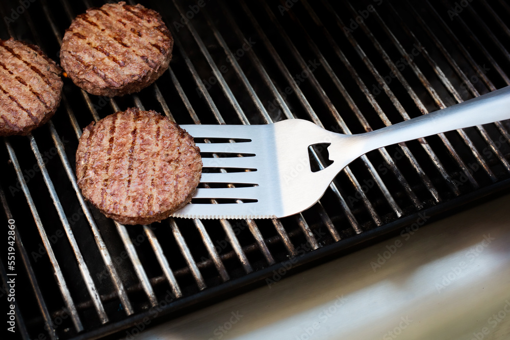 burgers and spatula on barbecue burgers and spatula on barbecue