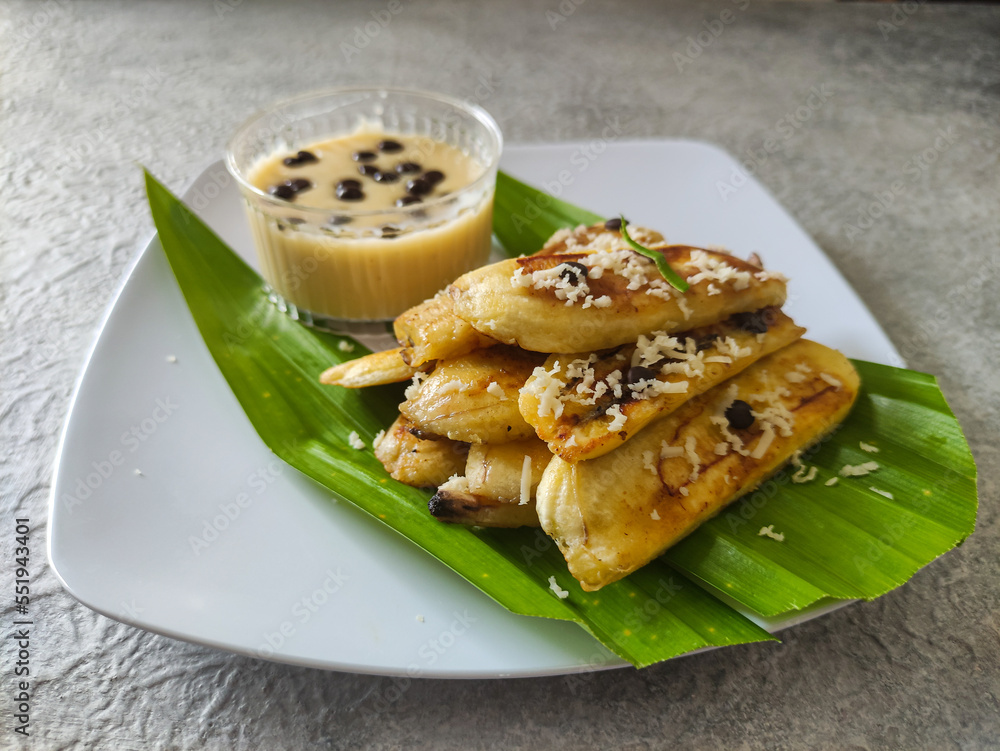 Grilled banana served with cheese sauce and chocolate chips on the white plate and placed on grey textured background. Selective focus image.
Grilled banana served with cheese sauce and chocolate chips on the white plate and placed on grey textured background. Selective focus image.