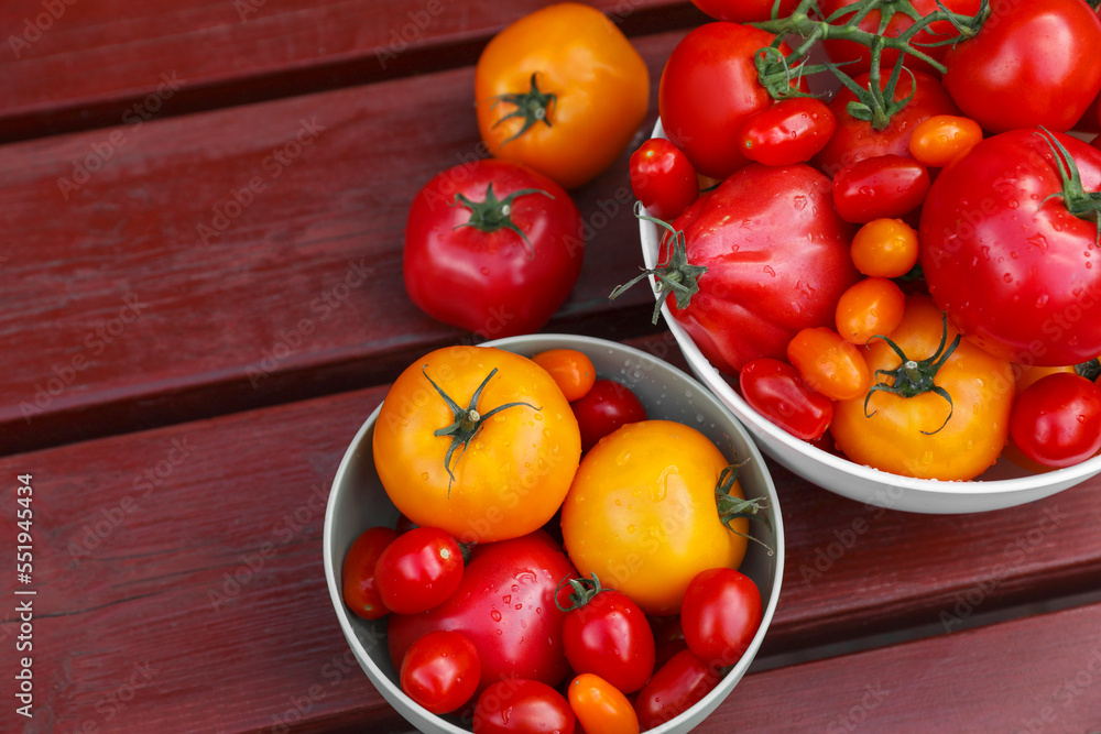 Bowls with fresh tomatoes on wooden table, flat lay. Space for text Bowls with fresh tomatoes on wooden table, flat lay. Space for text