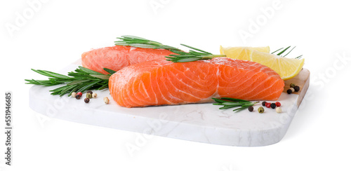 Pieces of fresh raw salmon, spices and lemon slices on white background