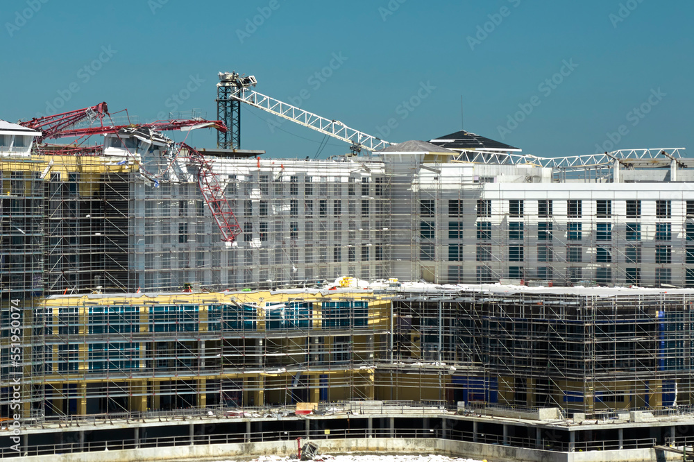 Aerial view of ruined by hurricane Ian construction crane on high apartment building site in Port Charlotte, USA Aerial view of ruined by hurricane Ian construction crane on high apartment building site in Port Charlotte, USA