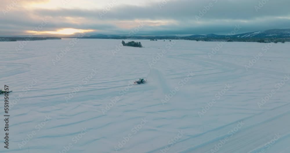 Norbotten tractor snow blower preparing vast ice driving track aerial orbiting view Norbotten tractor snow blower preparing vast ice driving track aerial orbiting view