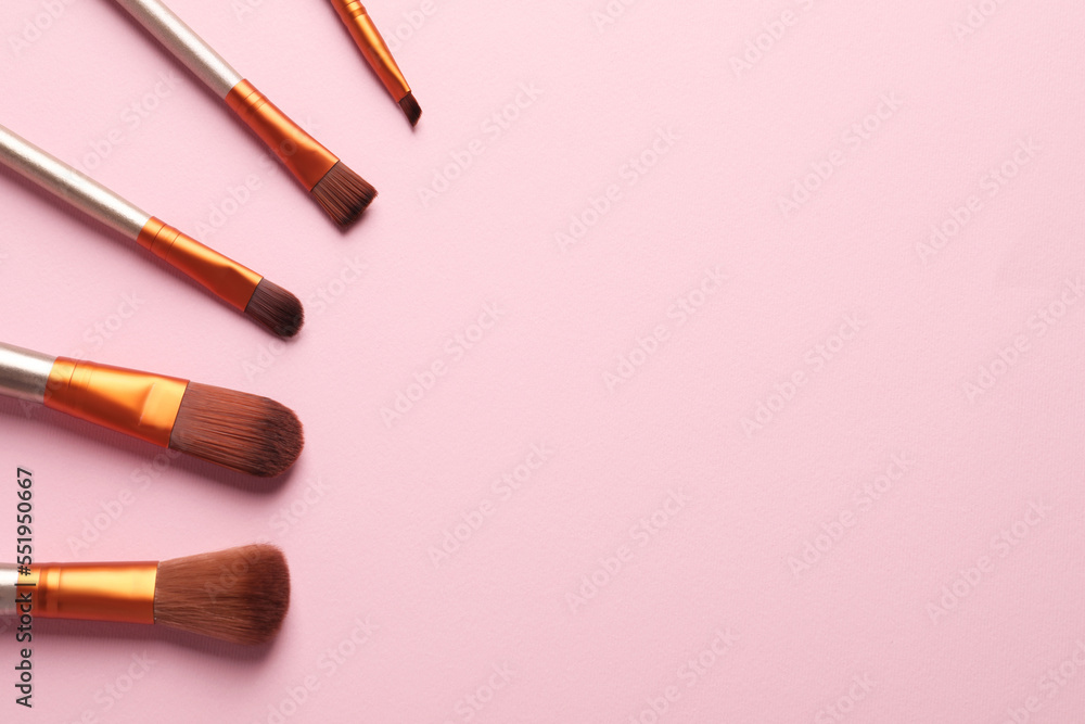 Set of makeup brushes on pink background, flat lay. Space for text Set of makeup brushes on pink background, flat lay. Space for text