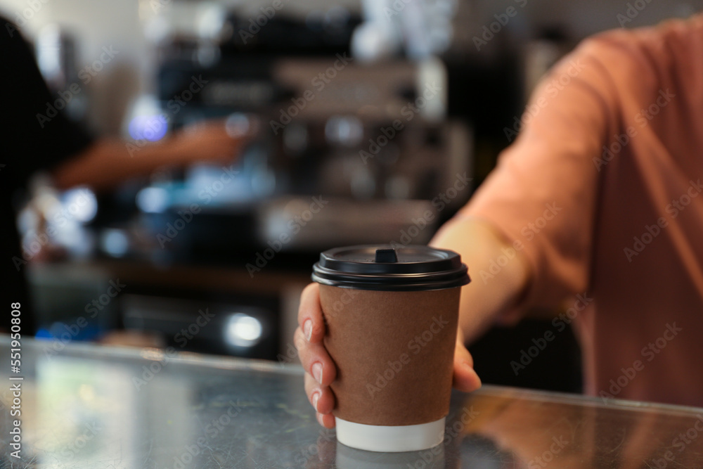 Barista putting takeaway paper cup with coffee on countertop in cafe, closeup Barista putting takeaway paper cup with coffee on countertop in cafe, closeup