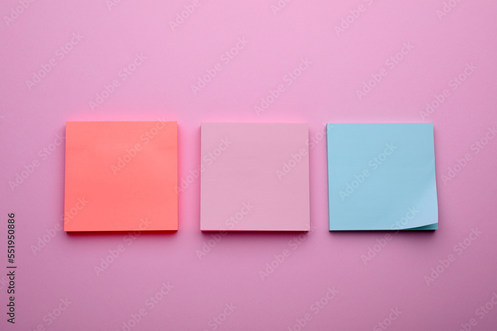 Paper notes on pale pink background, flat lay Paper notes on pale pink background, flat lay