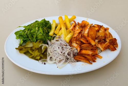 Turkish and Arabic Traditional Ramadan doner kebab with tasty tomato sauce and rice or turkish pilav in white plate on wood table background. ( Pilav ustu doner) photo