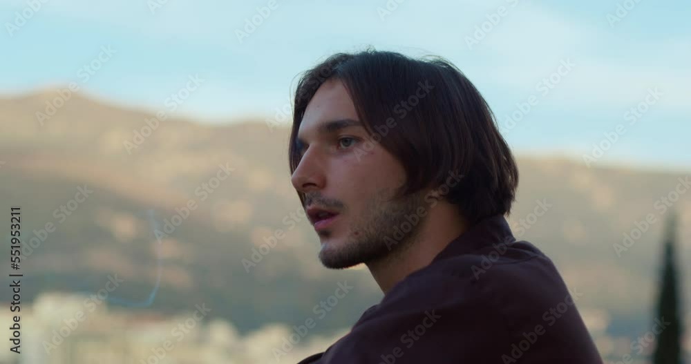 Unshaven brutal guy stubble is standing on balcony against background of sky mountains, looking at one point in daze Worker it emotional burnout relocation homesickness Cigarette addiction depression Unshaven brutal guy stubble is standing on balcony against background of sky mountains, looking at one point in daze Worker it emotional burnout relocation homesickness Cigarette addiction depression