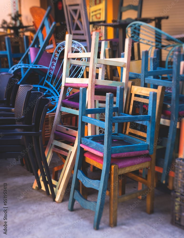 Chairs piled up in empty cafe, the end of touristic season, closed restaurant in the european streets, bad season, end of working hours, seats stacked in after hours, restaurant went bust bankrupt Chairs piled up in empty cafe, the end of touristic season, closed restaurant in the european streets, bad season, end of working hours, seats stacked in after hours, restaurant went bust bankrupt