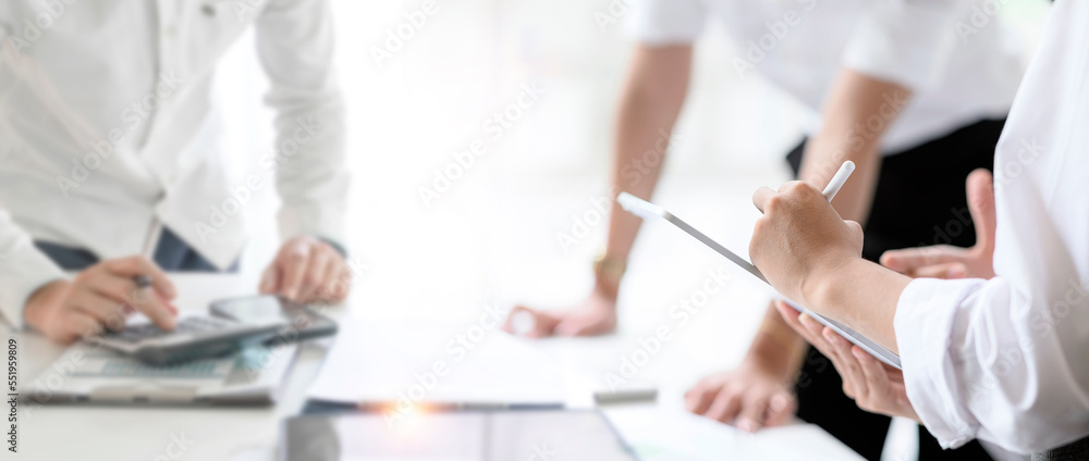 Female hand using stylus pen and tablet working with team designer at modern office. Female hand using stylus pen and tablet working with team designer at modern office.