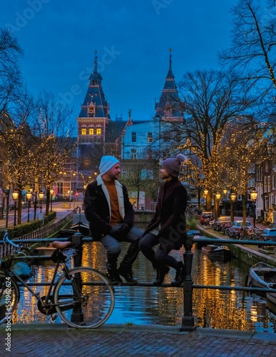 Photography a couple on a city trip in Amsterdam with Christmas lights at the canals during