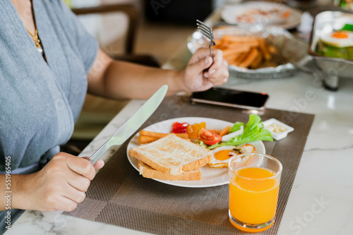 Closeup on a young woman she is having breakfast.