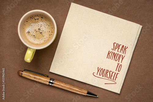 speak kindly to yourself - inspirational reminder on a napkin with a cup of coffee, personal development concept