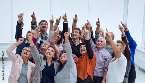 a group of older people raised their hands trying to reach © ASDF