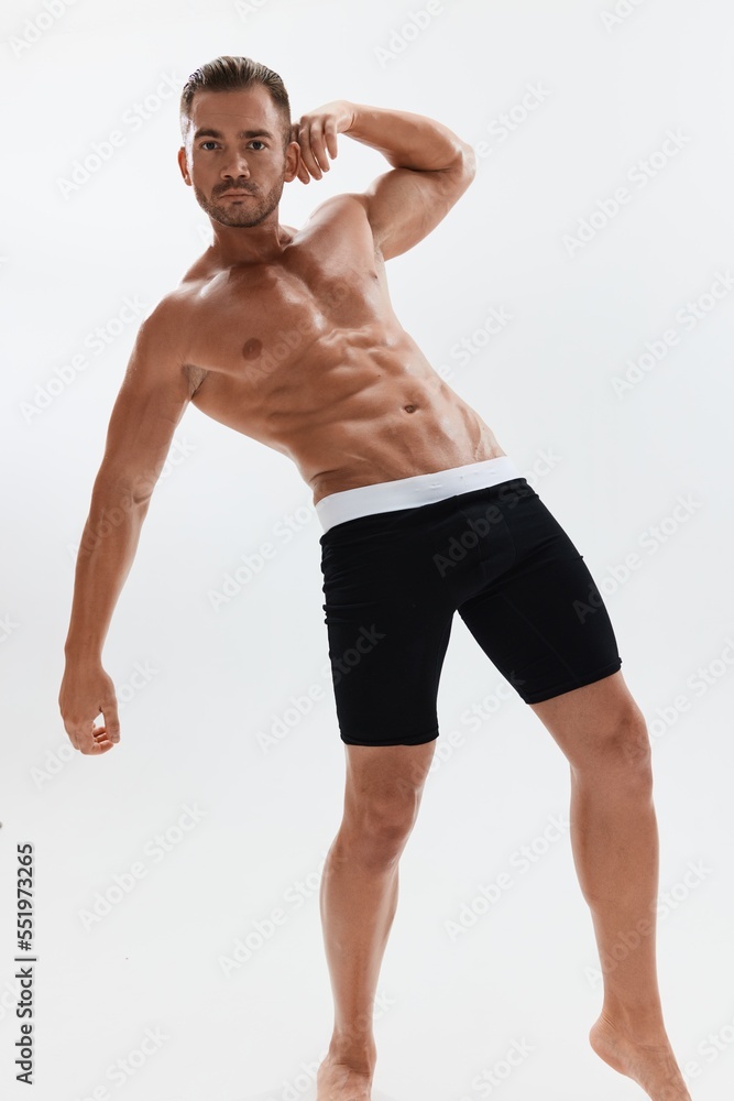 Man athletic body bodybuilder in briefs with naked torso abs full-length in the background, fitness classes. Advertising, sports, active lifestyle, competition, challenge concept. Man athletic body bodybuilder in briefs with naked torso abs full-length in the background, fitness classes. Advertising, sports, active lifestyle, competition, challenge concept.