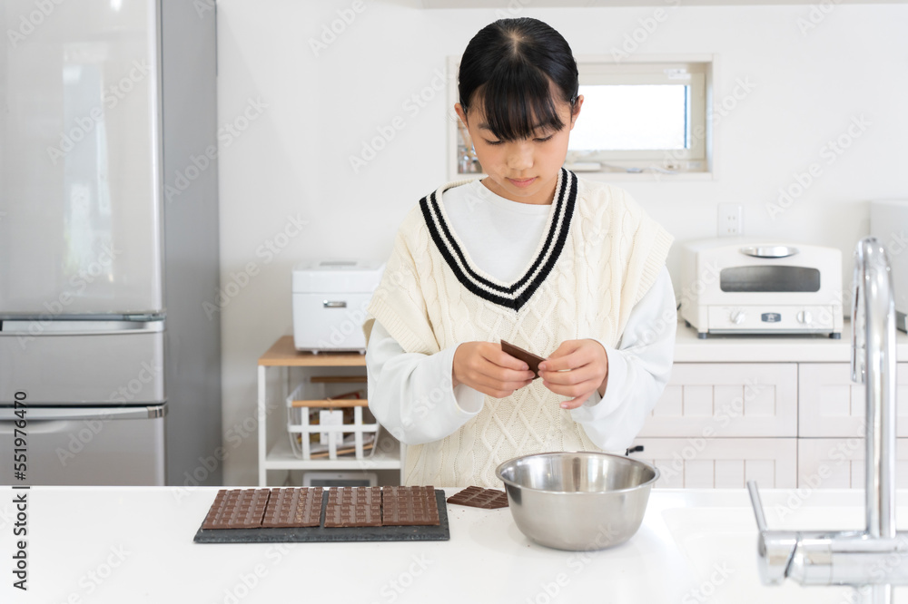 チョコレートを割る小学生の女の子